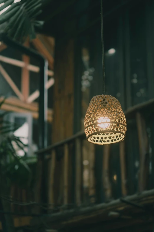 a hanging light made out of brown rattan