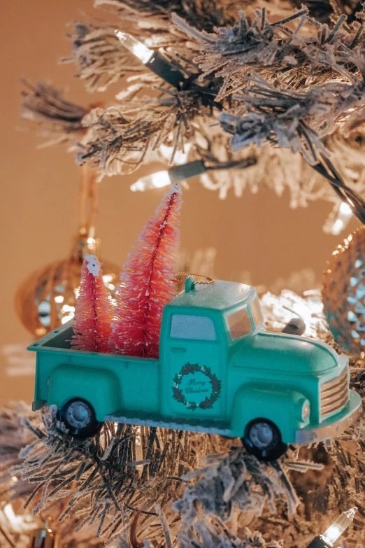 the green truck is under the christmas tree