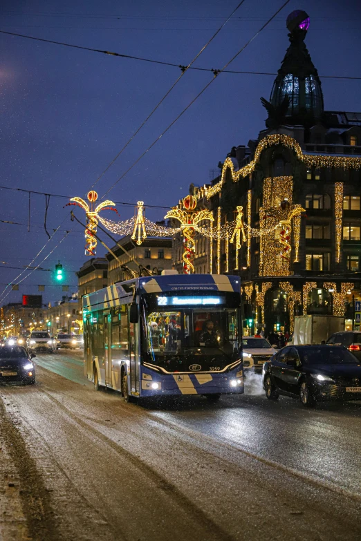 a public transit bus drives down a busy street decorated for christmas