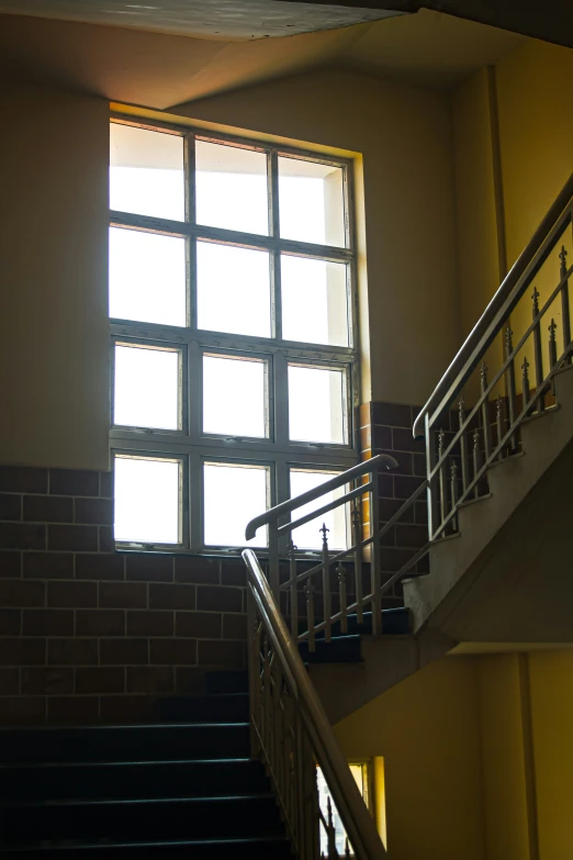 a stair way with a brick wall, and sun window