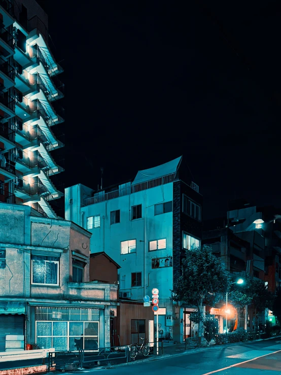 several buildings line the streets at night in an area where there are no people