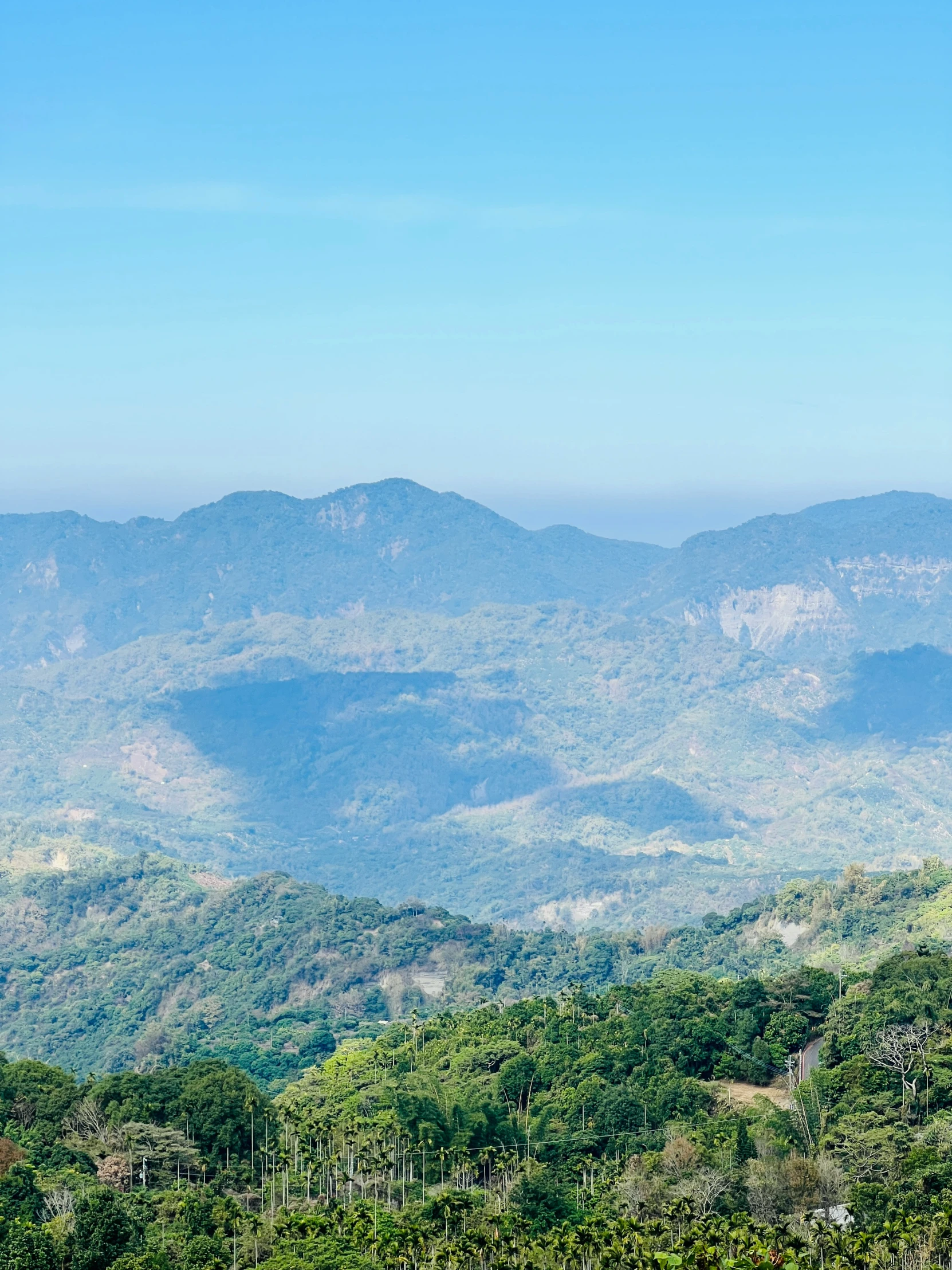 the view looking down at a lush green valley in the distance