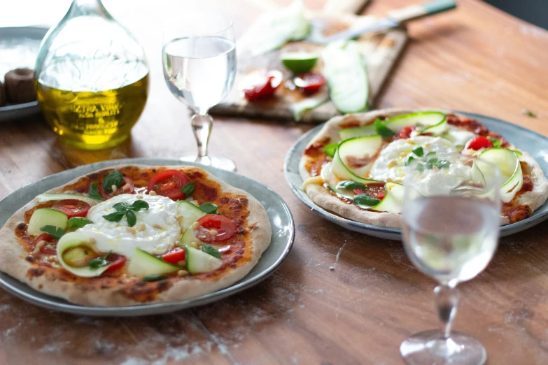 a table with three pizzas and two flutes