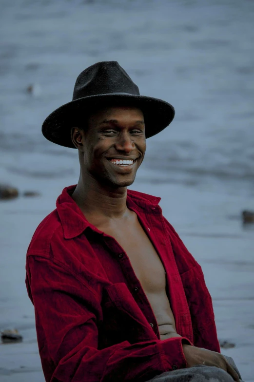 a man wearing a red shirt smiles at the camera