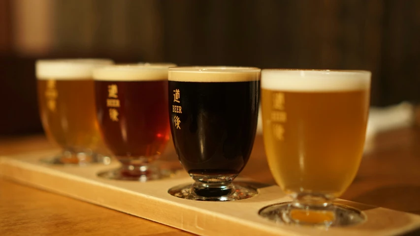 four beer glasses in front of some other glasses