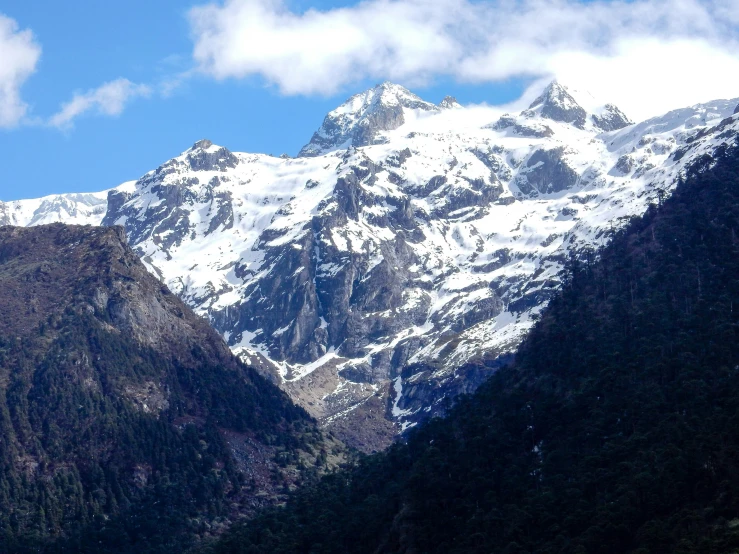 mountain range in front of blue sky and clouds