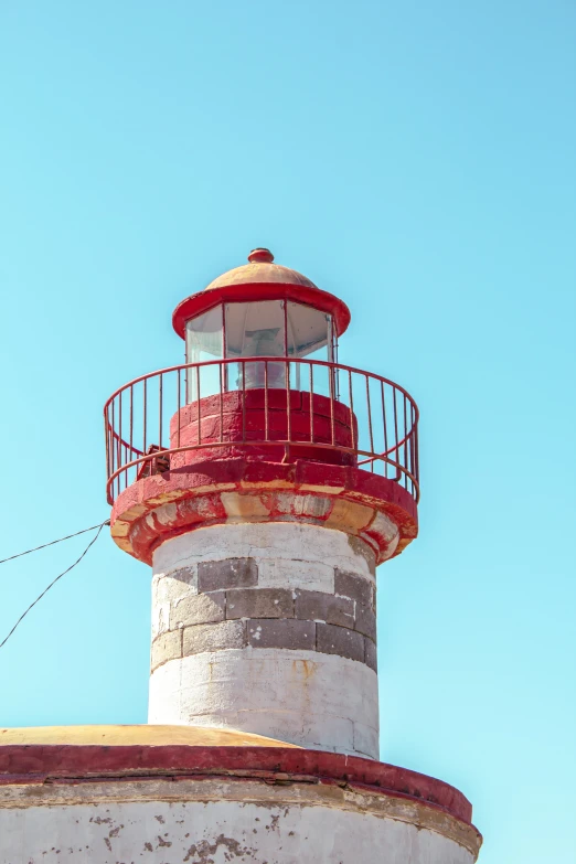 a picture of a small light house with red windows