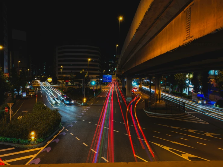 a street with lots of cars passing down it at night