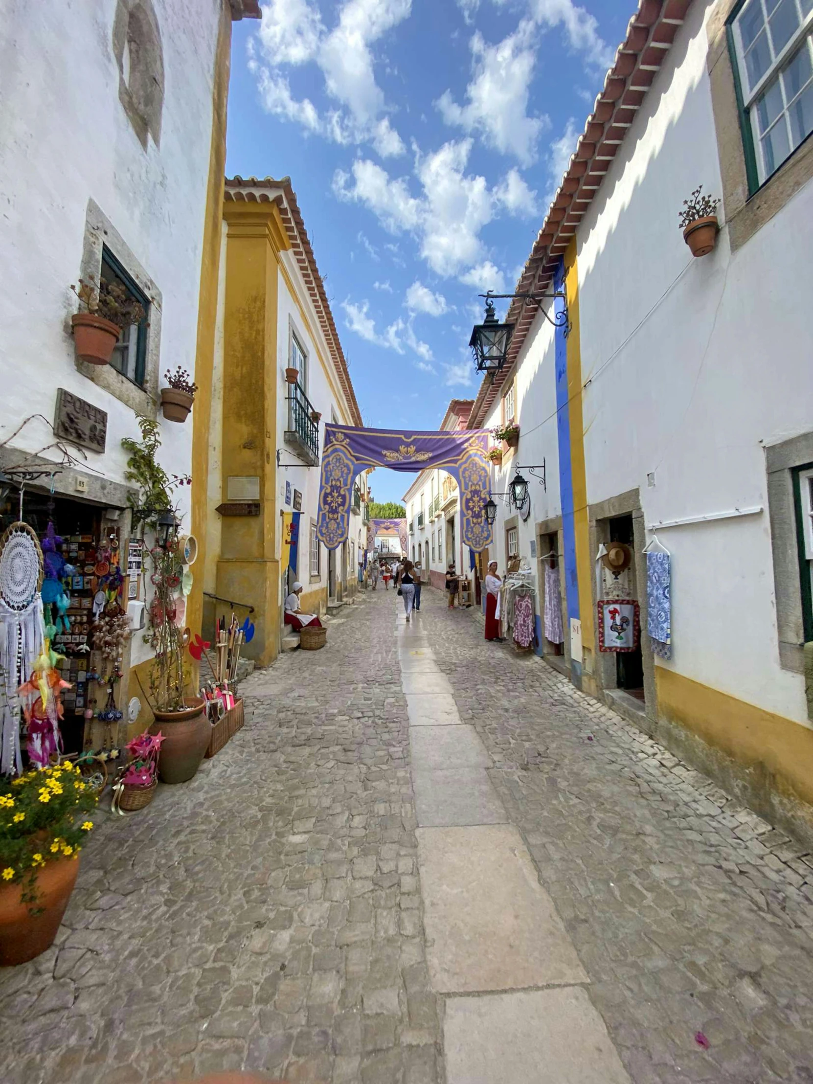 a narrow street with shops and restaurants near by