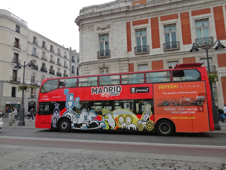 a red double decker bus is on the street