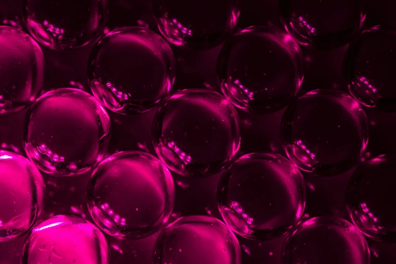 a large group of small round glass spheres in purple