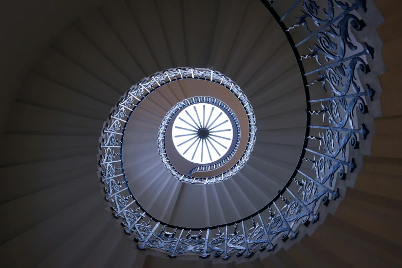 a spiral staircase is lit by the light coming through it