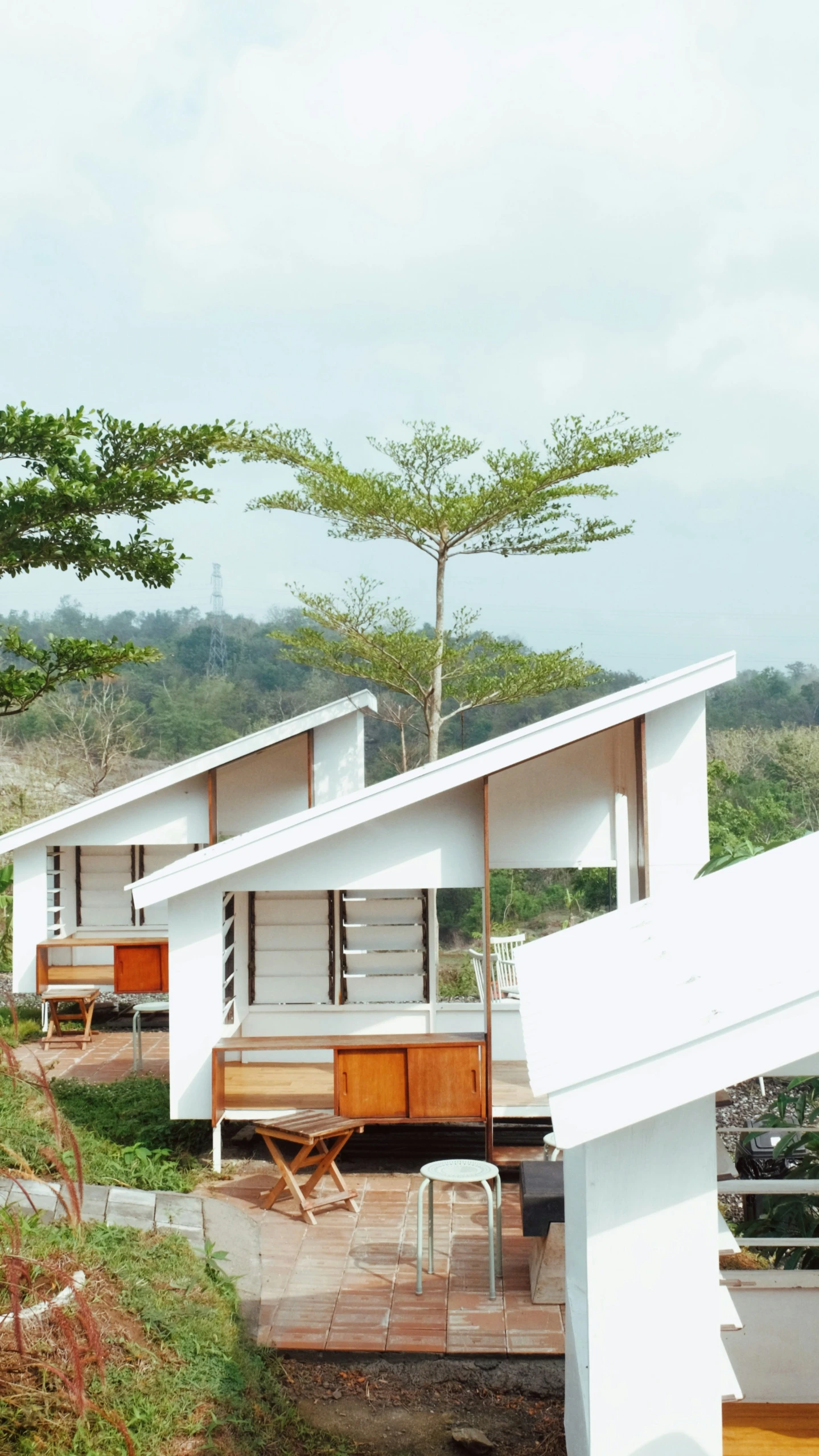 an outdoor pavilion on top of a deck with chairs and tables