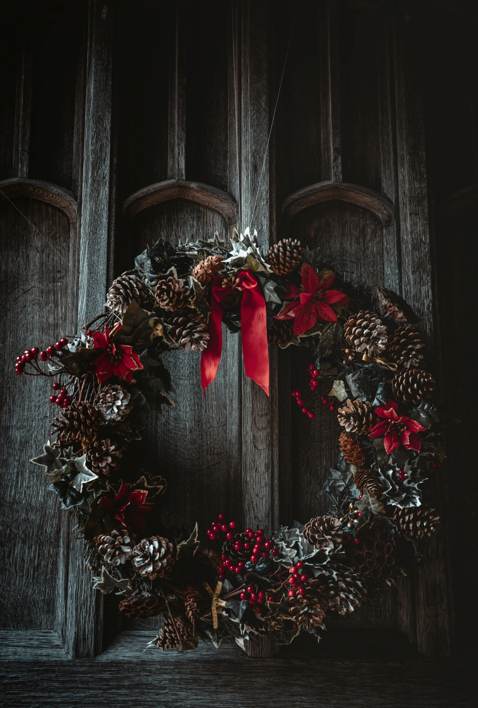 a decorative wreath hung outside of a wooden door