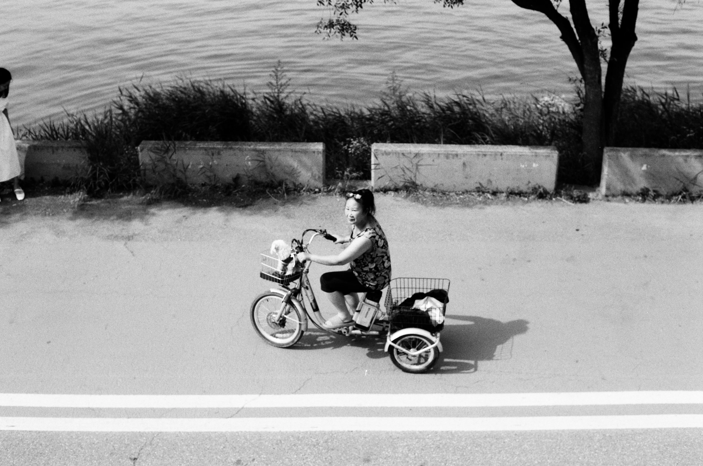 a woman and a child with a baby stroller while standing on the sidewalk