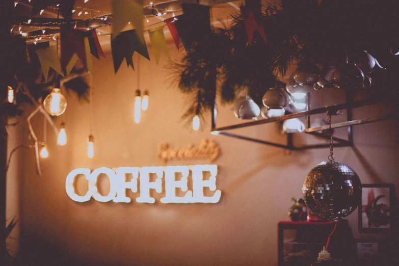 the light at the top of a coffee shop sign is dim