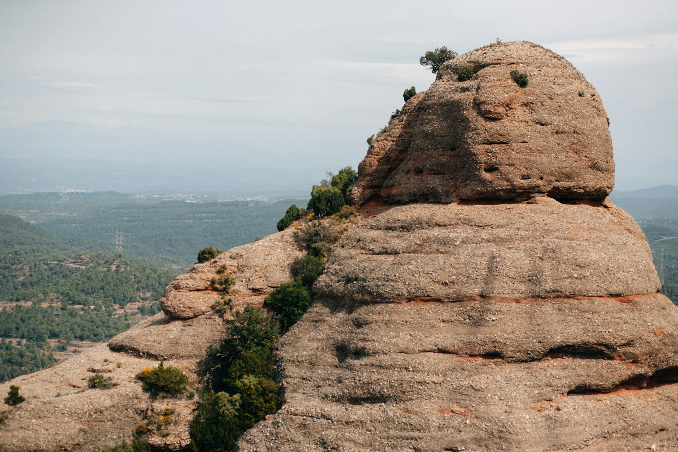 the large rock is standing next to the hillside