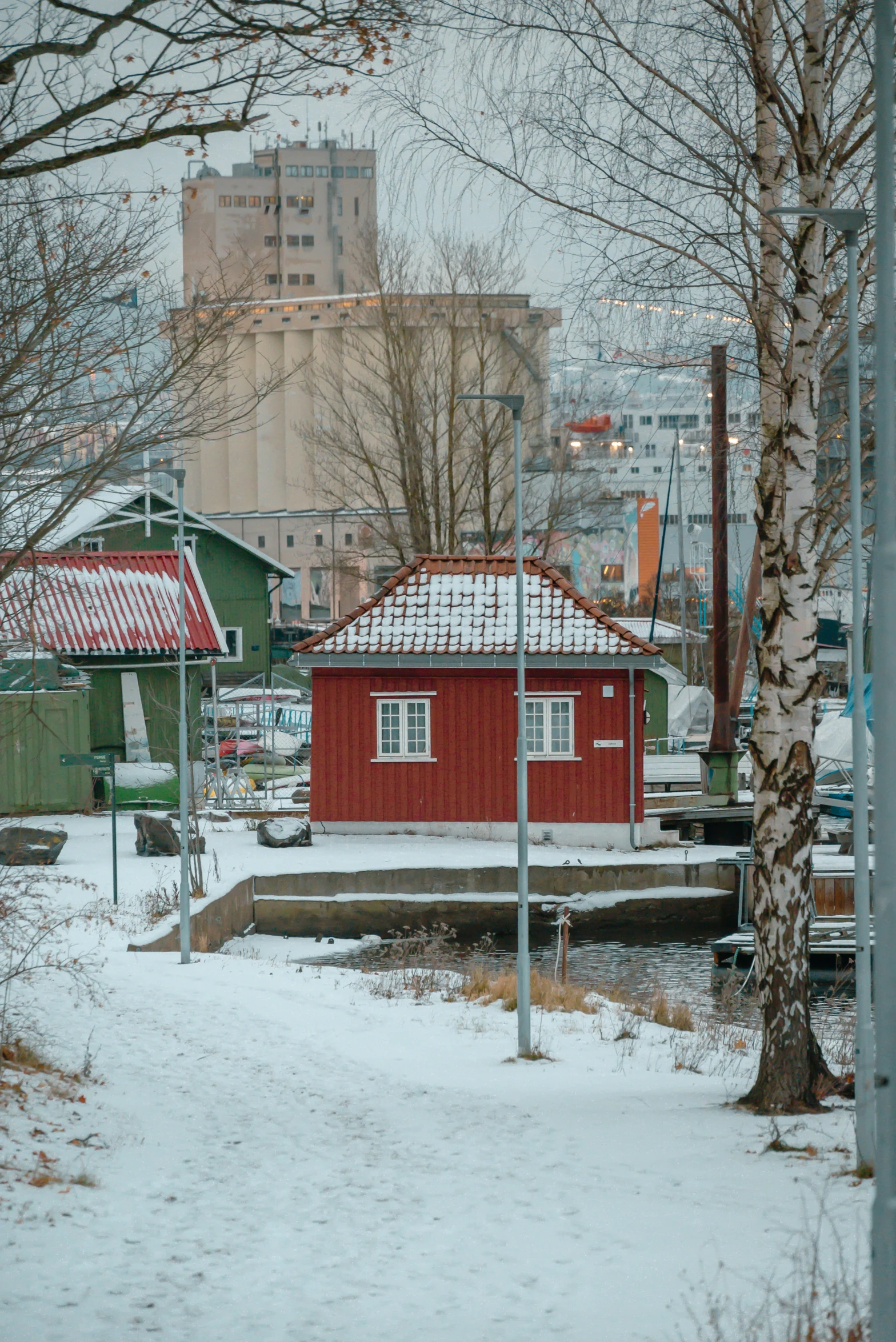 a small red building with red roof covered in snow