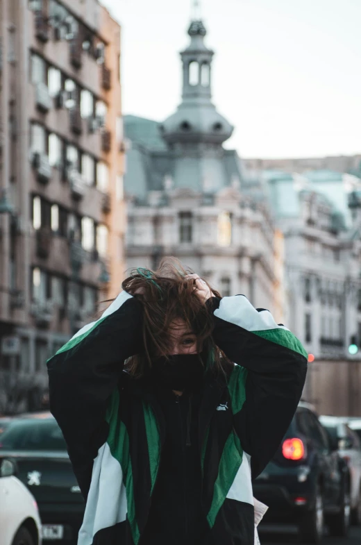 a man who is covering his hair on a busy city street
