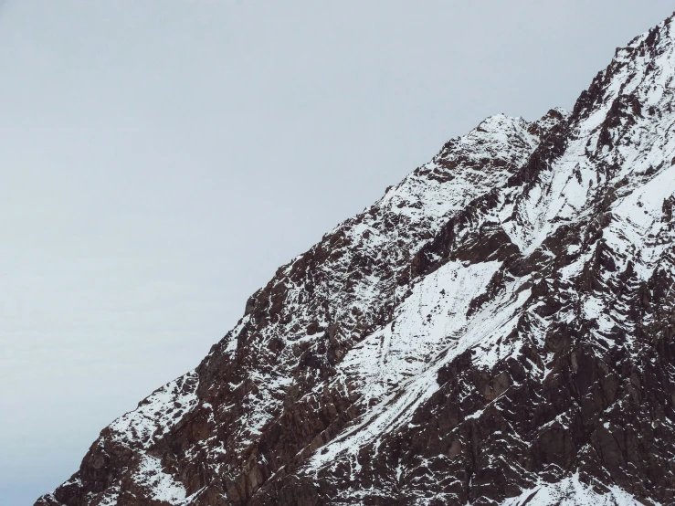 two people standing on a snowboard in front of a mountain