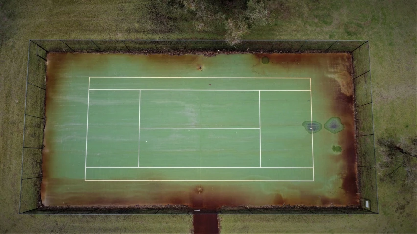 an old tennis court in the middle of the ground