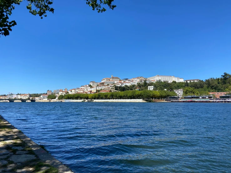 the clear water of a lake with some buildings and trees