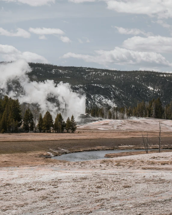 the steam is rising up into the mountains and over the river