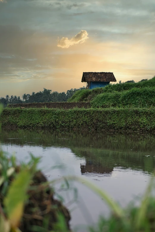 a po of an old hut by a lake