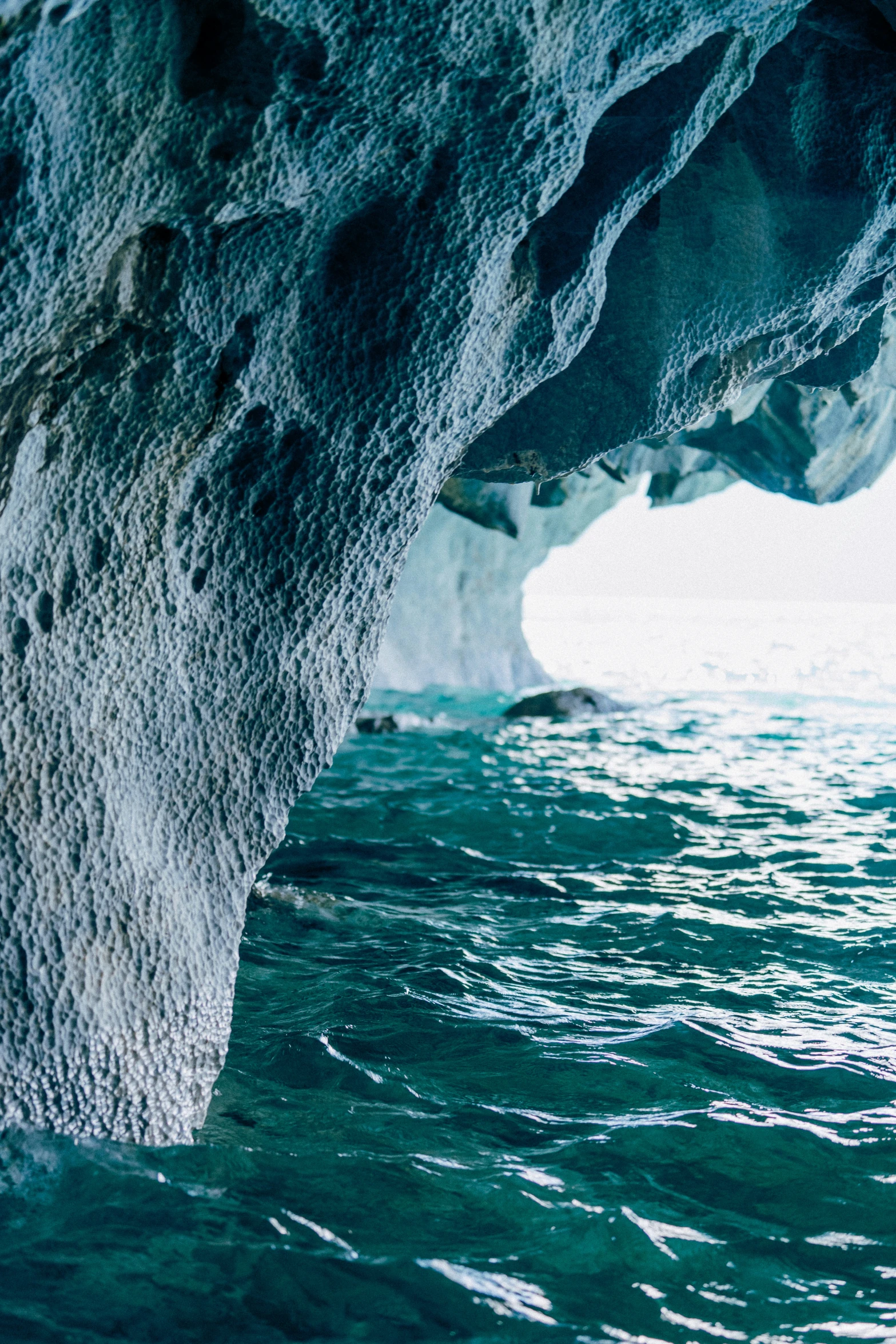 large ice cave with water in front of it