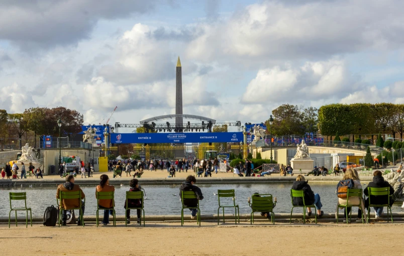 a group of people are sitting by the water