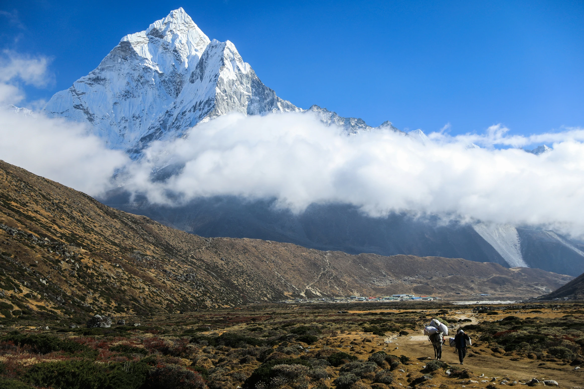 the mountains have snow capped peaks near people walking