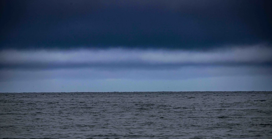 an ocean view with some very dark skies