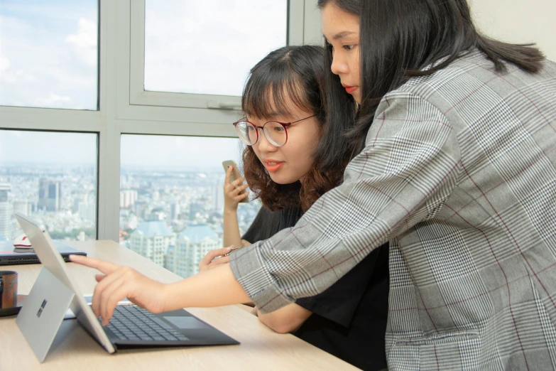 a woman and girl looking at an ipad computer