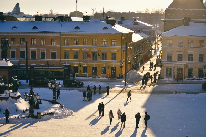 people walking through the snow and a few buildings