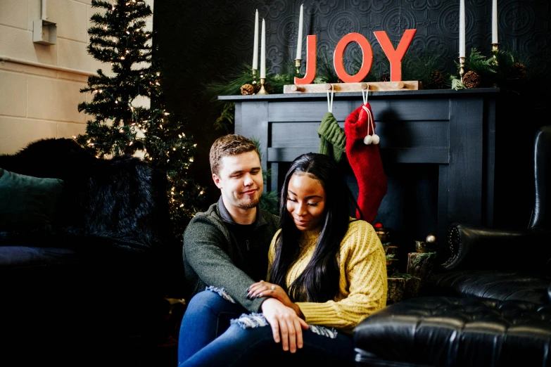 a man and a woman sitting beside a fireplace