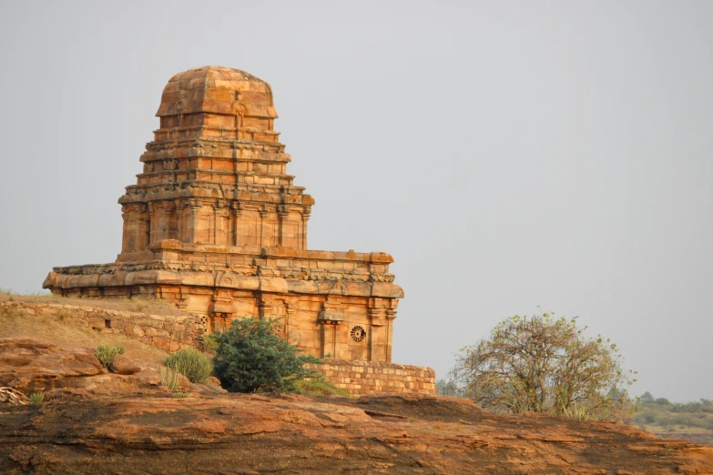an indian tower structure atop a hill with trees