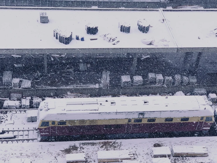 a train drives through snow covered town streets
