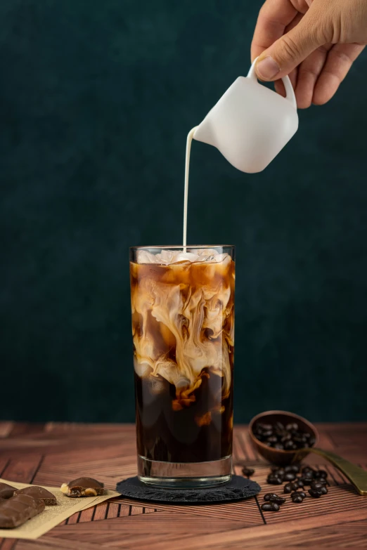 a person pouring drinks into a glass