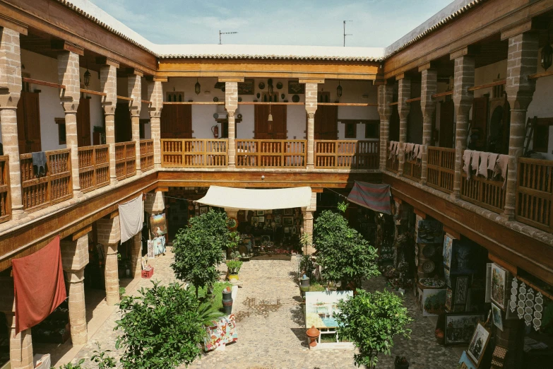 a courtyard is filled with trees, plants and awnings