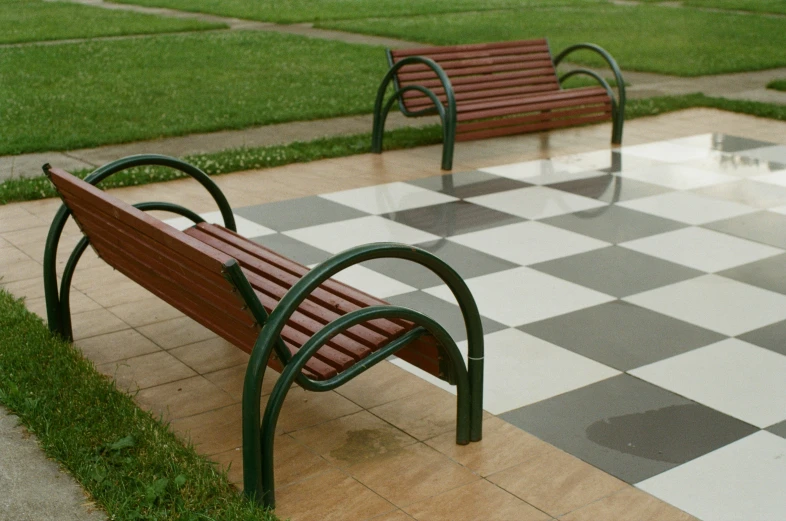 two empty benches on a patio near grass