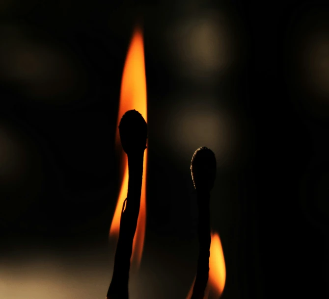 a candle sticks out of a dark room