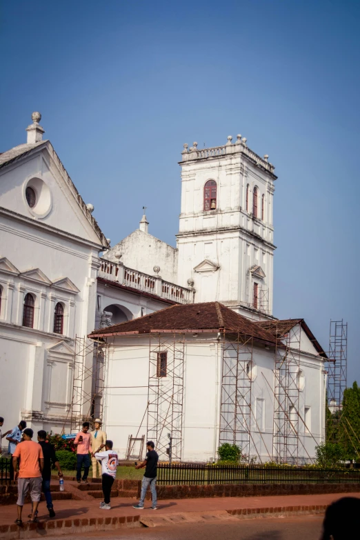 people walking and scaffolding in front of a church