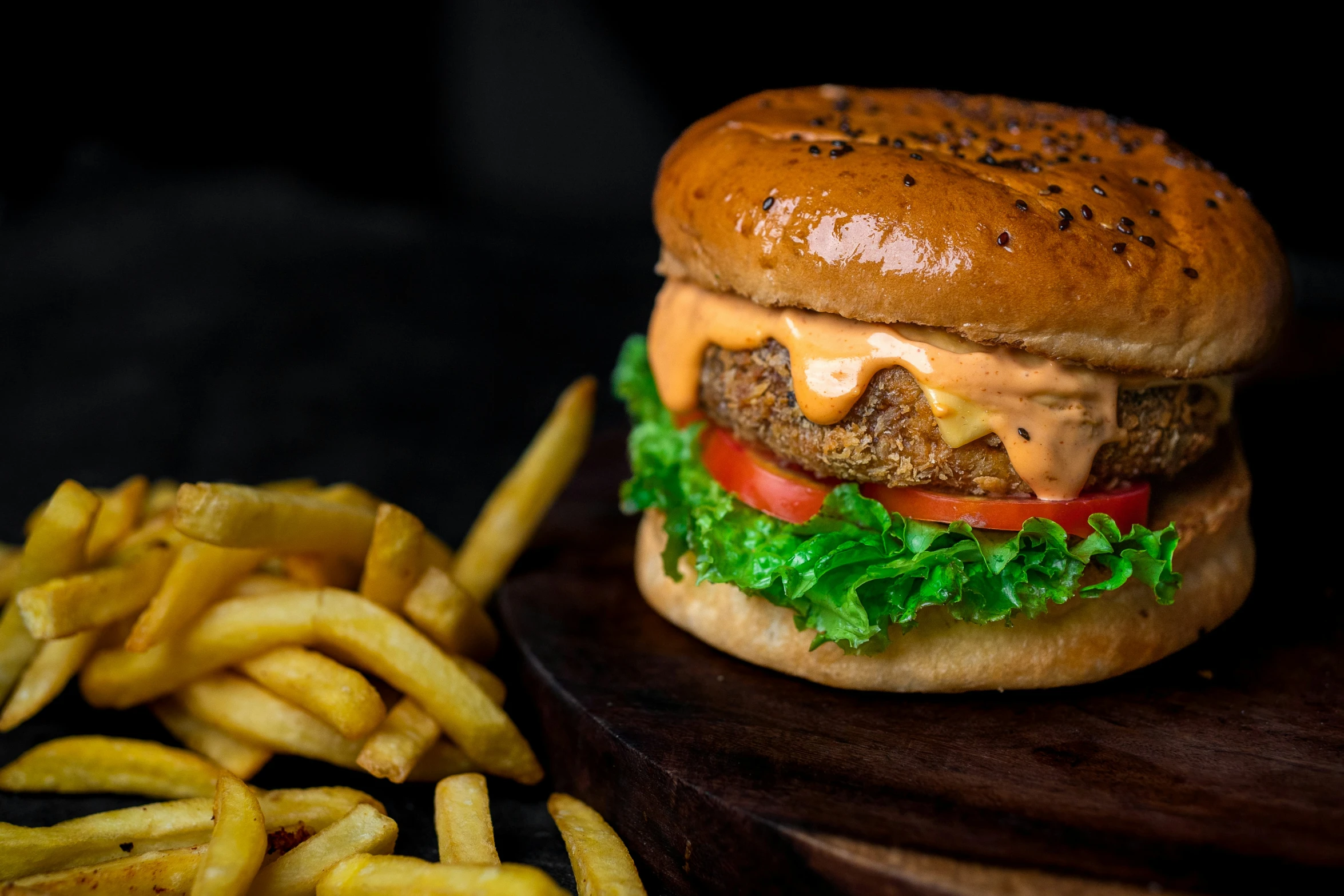 a cheeseburger and some french fries on a wooden surface