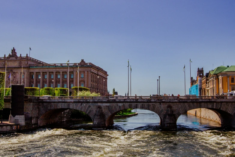 a large bridge over water with several buildings in the background