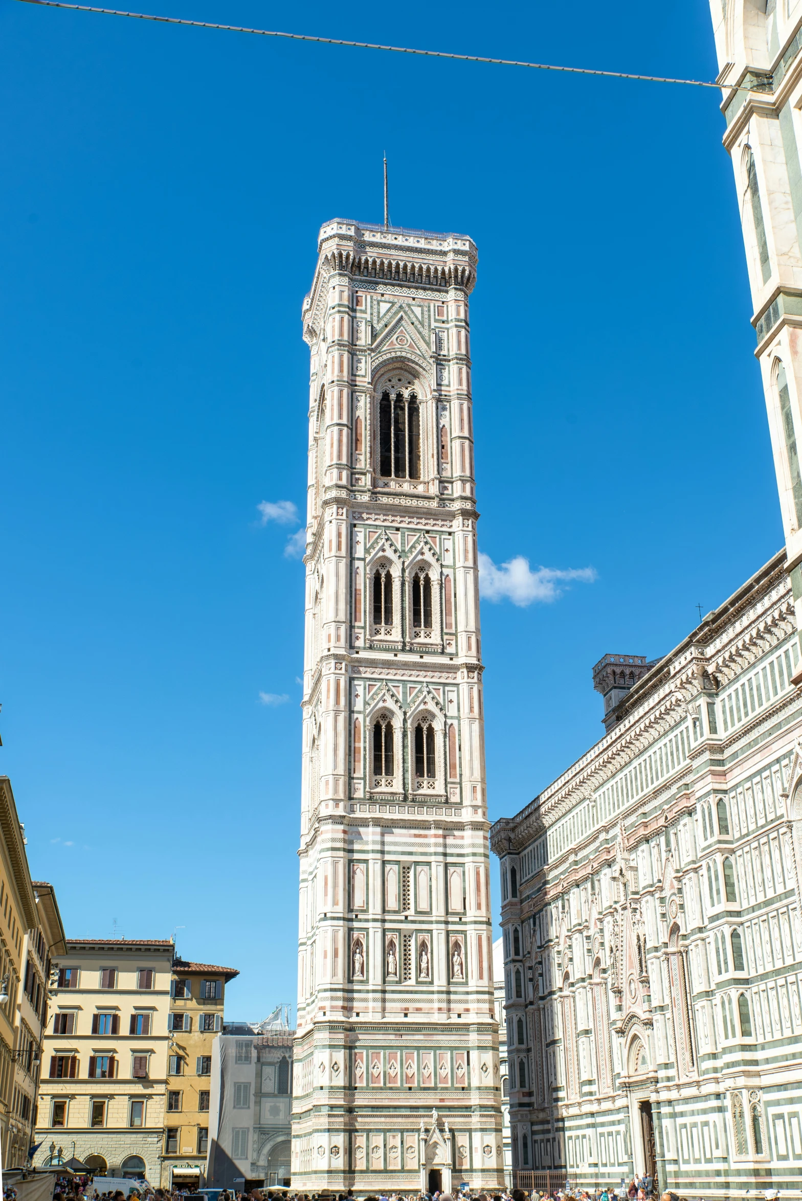 the tall clock tower is located next to buildings