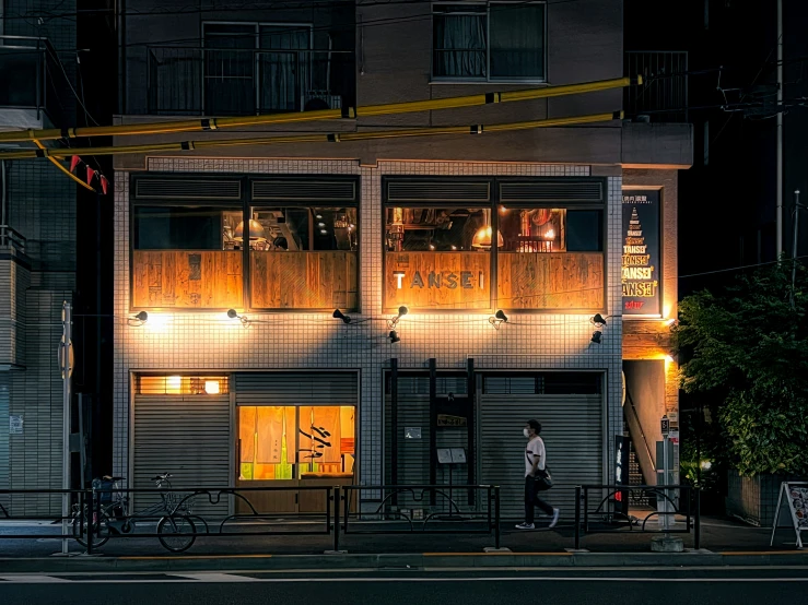 a man walking on the street at night under a street light