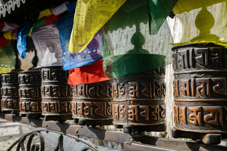 many bells hanging on the side of a wall