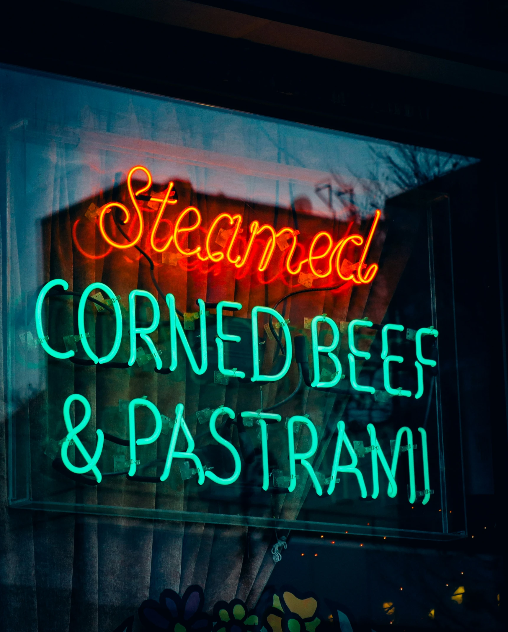 a neon sign reading steamed corned beef and pasta