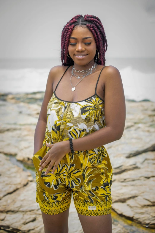 a woman is standing near the beach and touching her hands