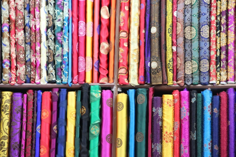 rows of colorful fabric at a market stall